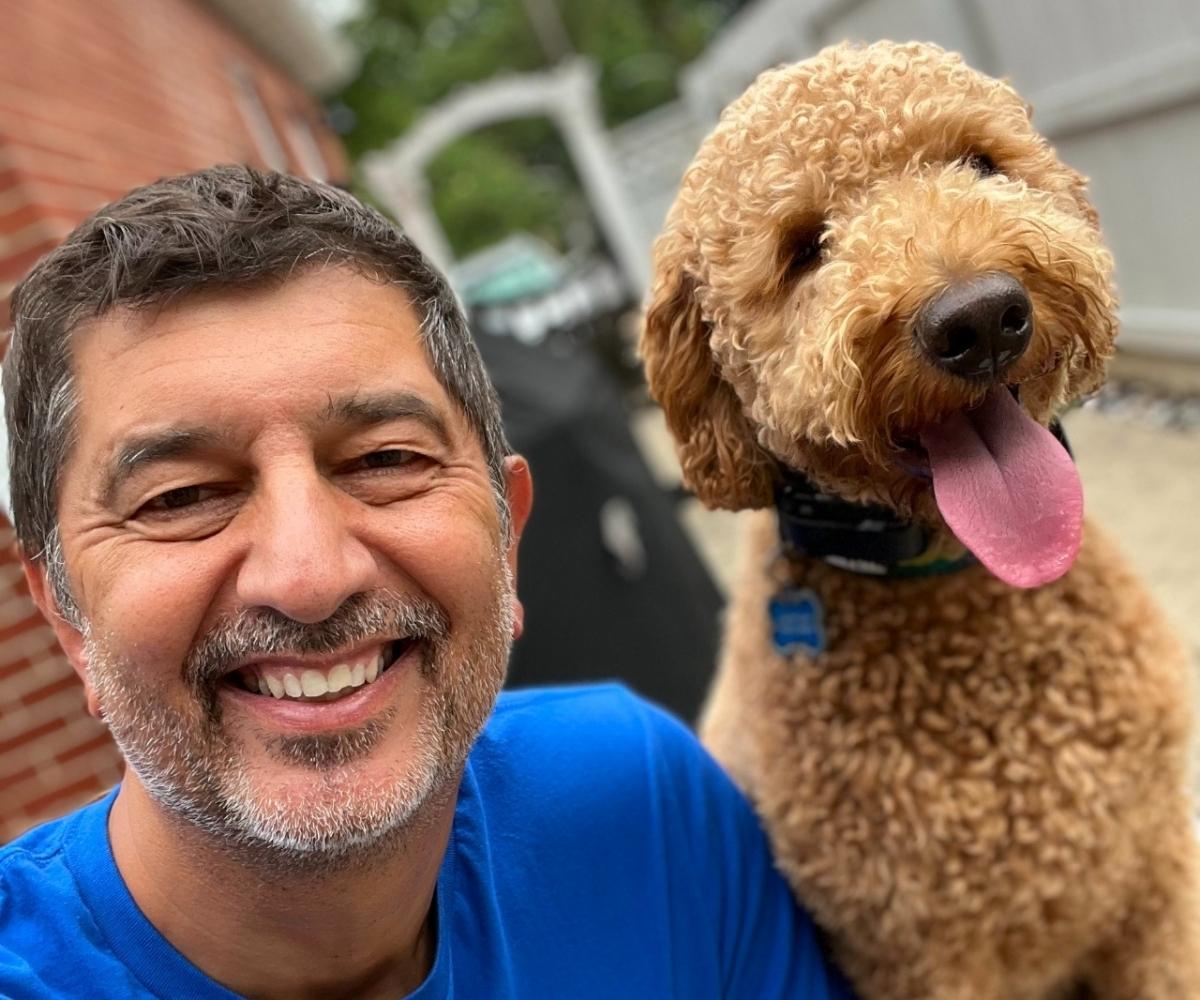 Turk Akbay Dog Owners Academy Founder Turk Akbay, founder of Dog Owner’s Academy, smiling with a happy dog during dog training in Charlotte, NC